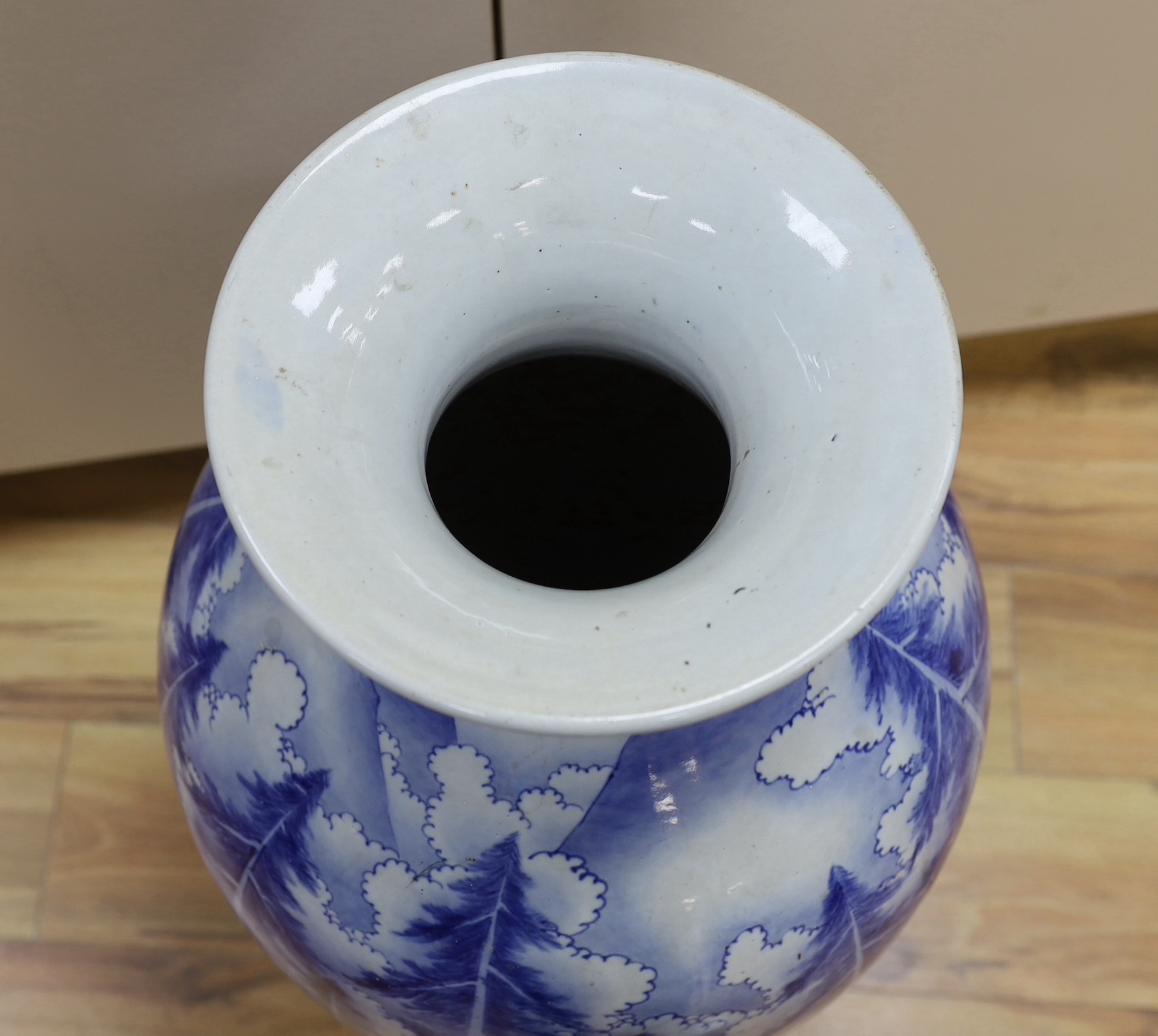 A large Japanese Arita blue and white vase, late 19th century, decorated with pine trees and mountains, 79cm high